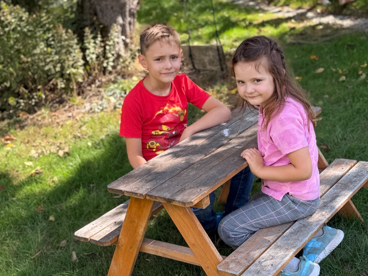 Kinder am Holztisch im Garten